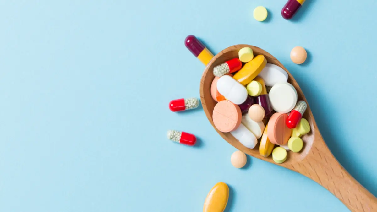 Viele unterschiedliche Tabletten auf einem Löffel