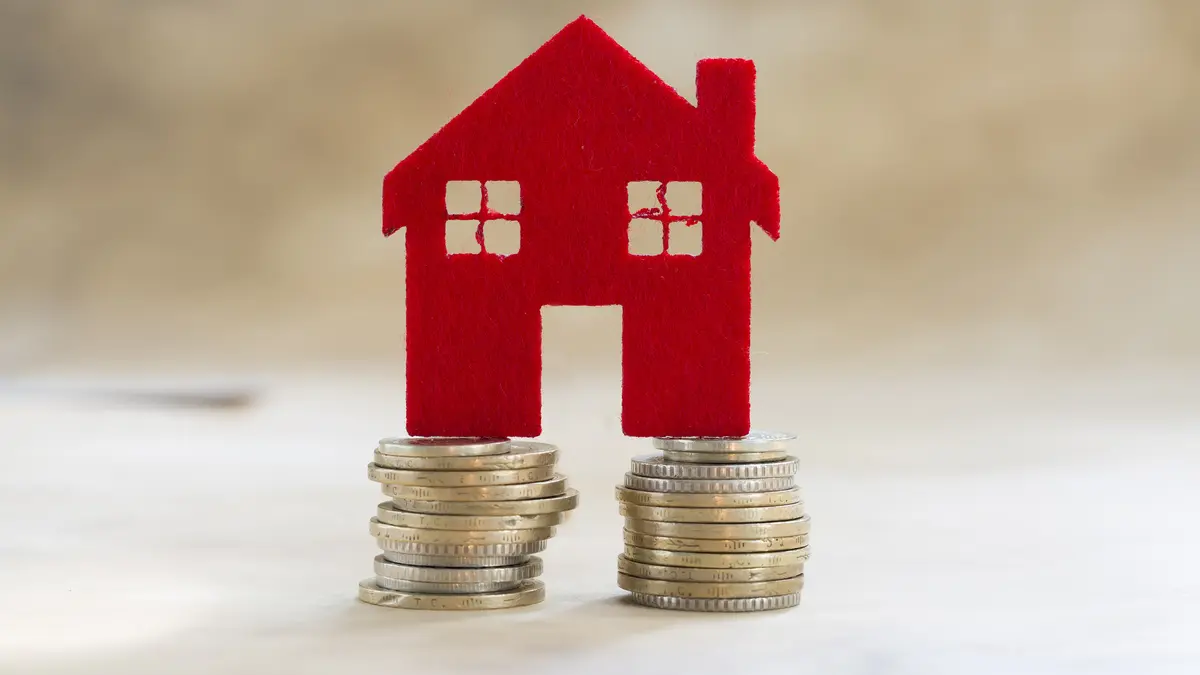 Haus aus Filz steht auf zwei Säulen aus Kleingeld