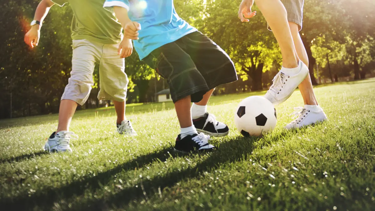 Jungen spielen Fußball auf der Wiese