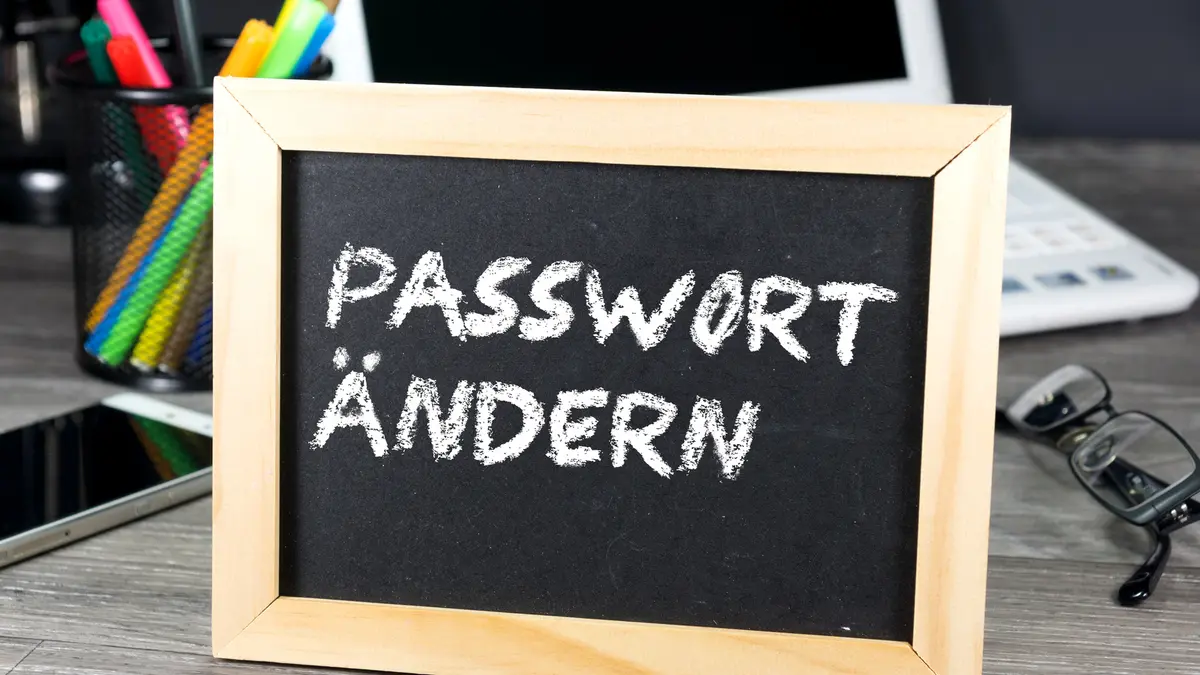 Vor einem Computer steht ein Schild und erinnert daran, das Passwort zu ändern.