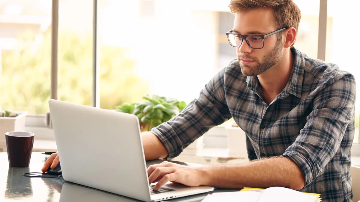 Mann sitzt vor Laptop