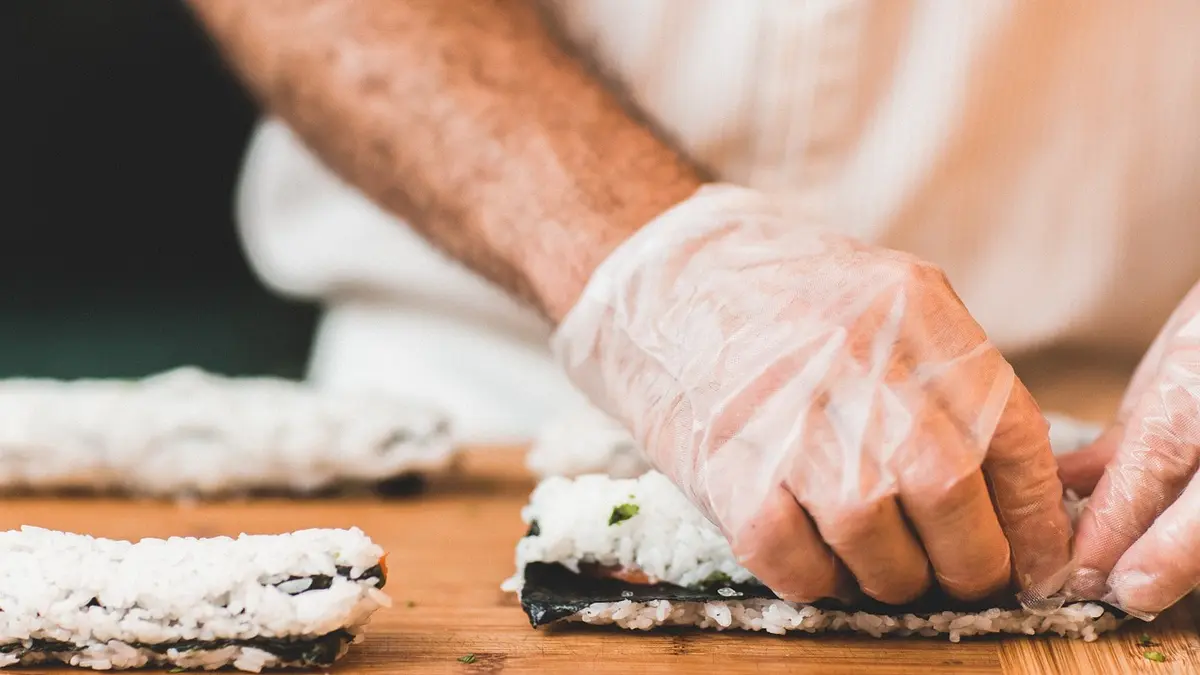 Ein Mann bereitet frisches Sushi zu