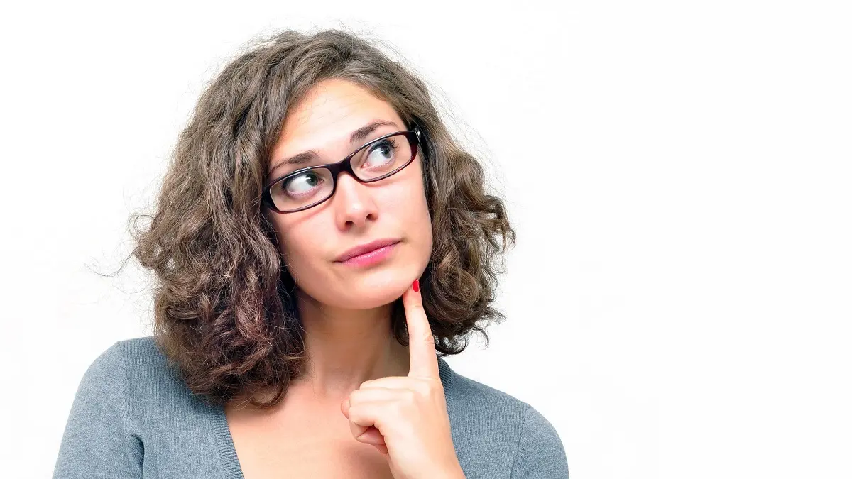 Frau mit Brille guckt fragend nach oben.
