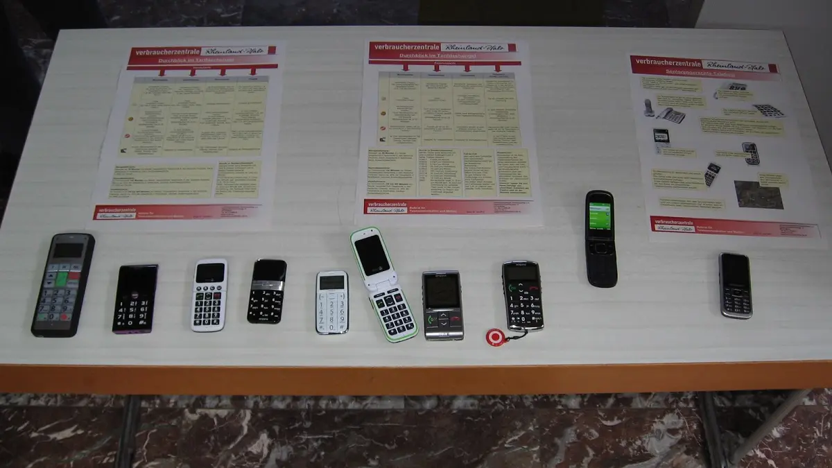 Auf einem Tisch liegen verschiedene Telefone und Handys.
