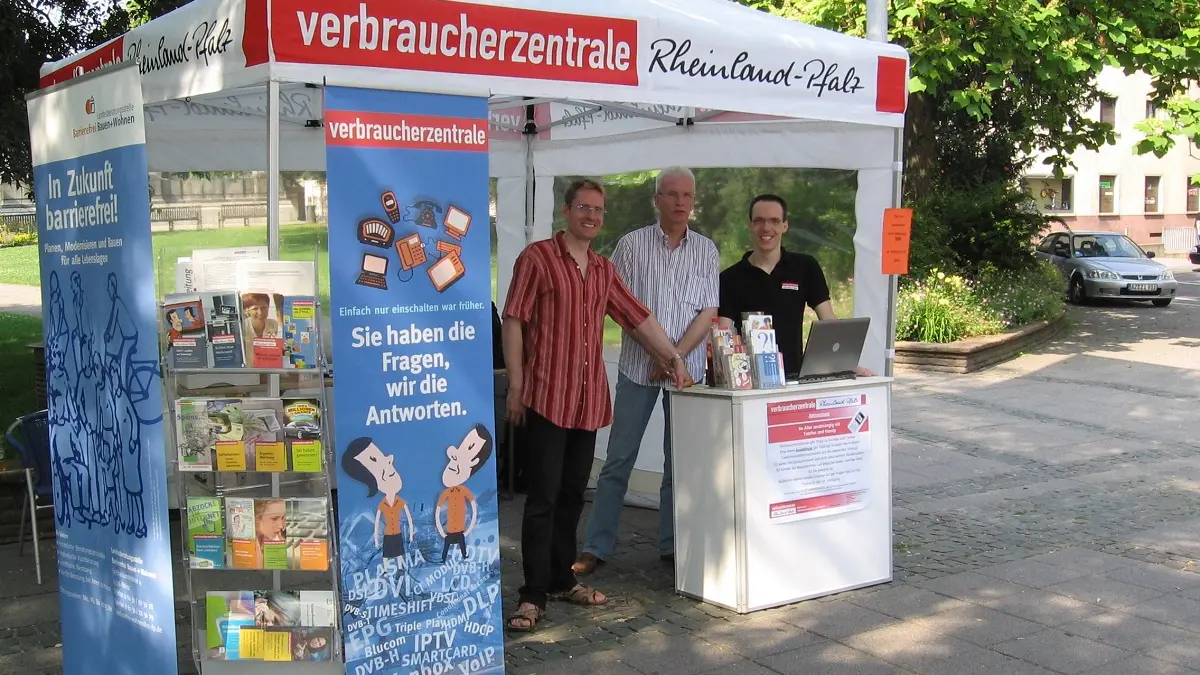 Ein Straßenstand mit Zelt und Personen davor.