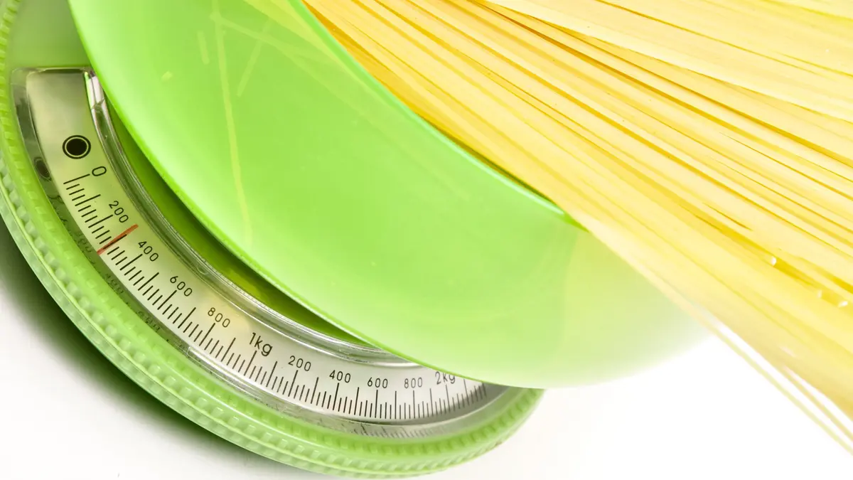ungekochte Spaghetti auf einer grünen Küchenwaage