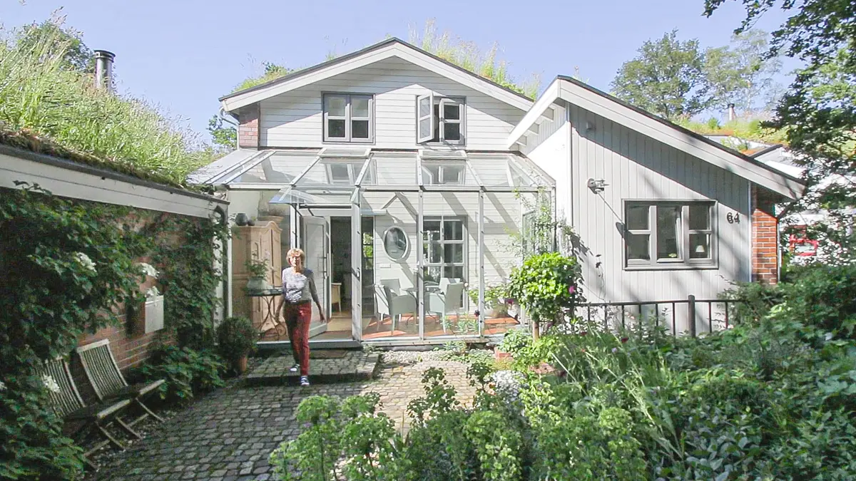 Beispiel Vorgarten mit Frau, die aus Haus kommt