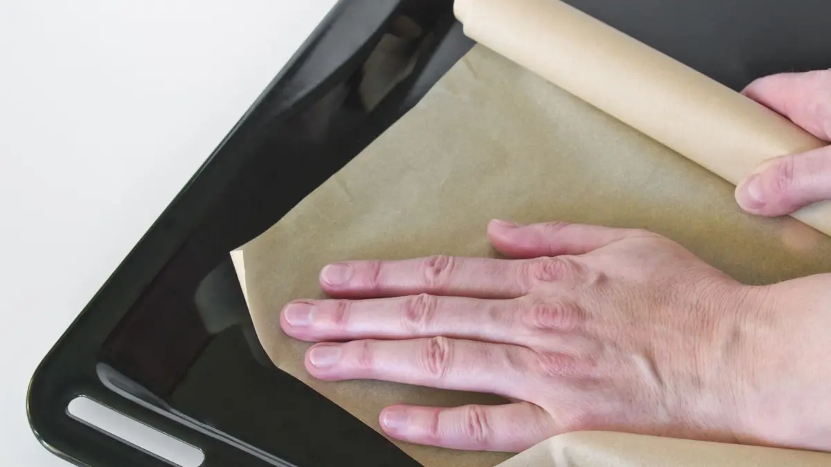 Ein Backblech wird mit Backpapier ausgelegt
