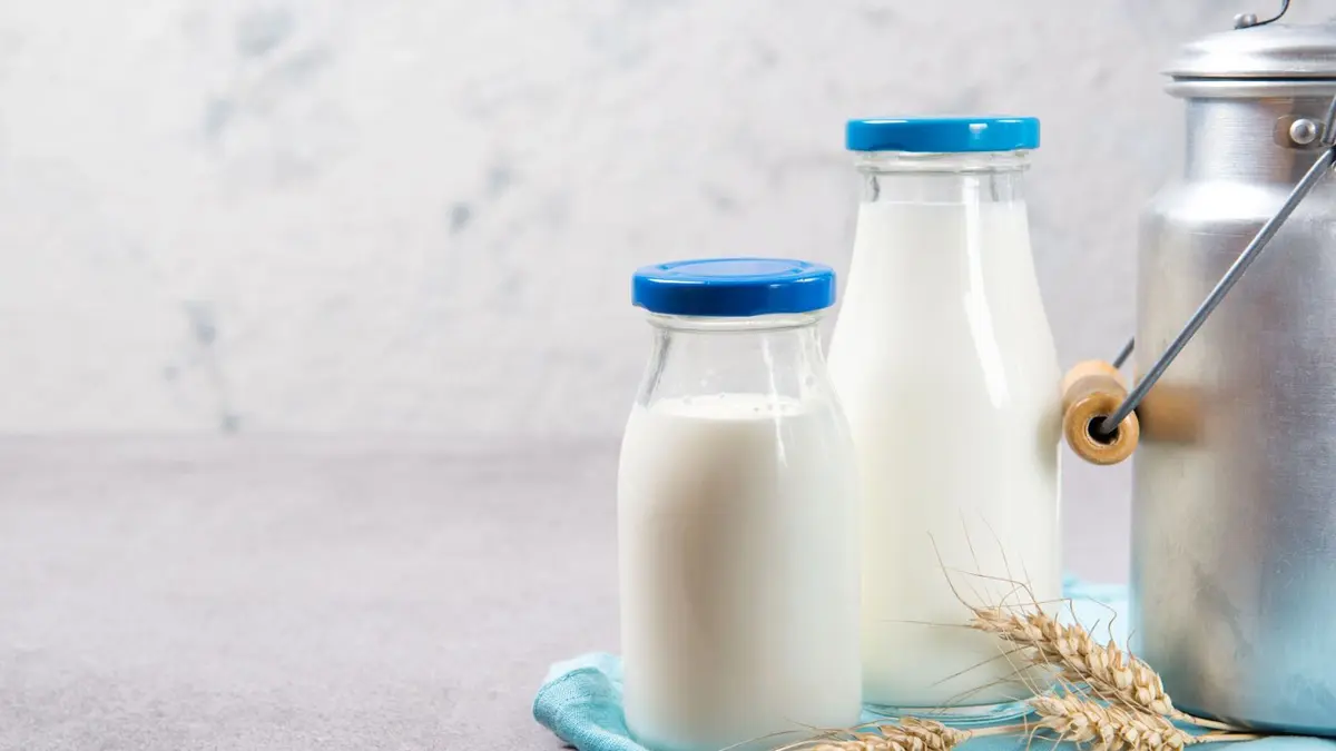 Milchflaschen und eine Milchkanne auf einem Tisch