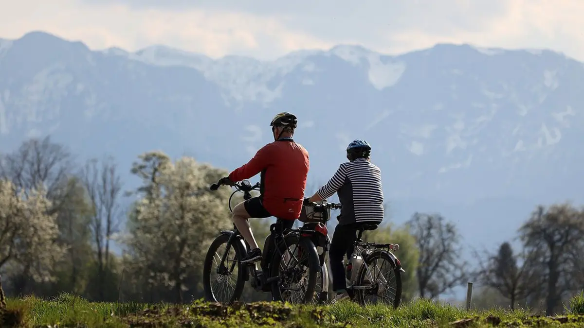 Ein älteres Paar auf E-Bikes in den Bergen
