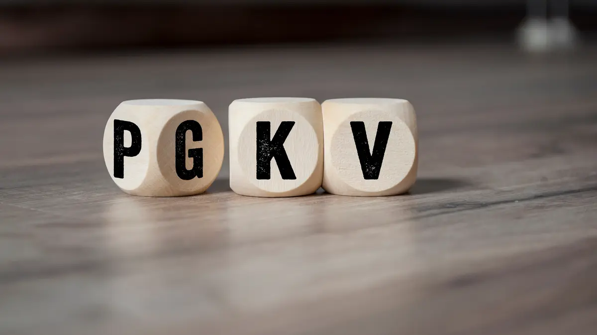 Drei Würfel, auf denen die Buchstaben P, G, K und V stehen