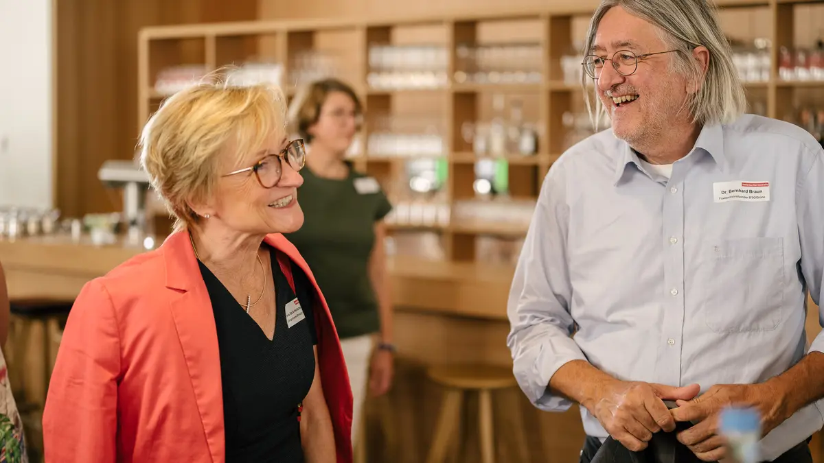 Zwei Menschen vor einer Bar im Gespräch.