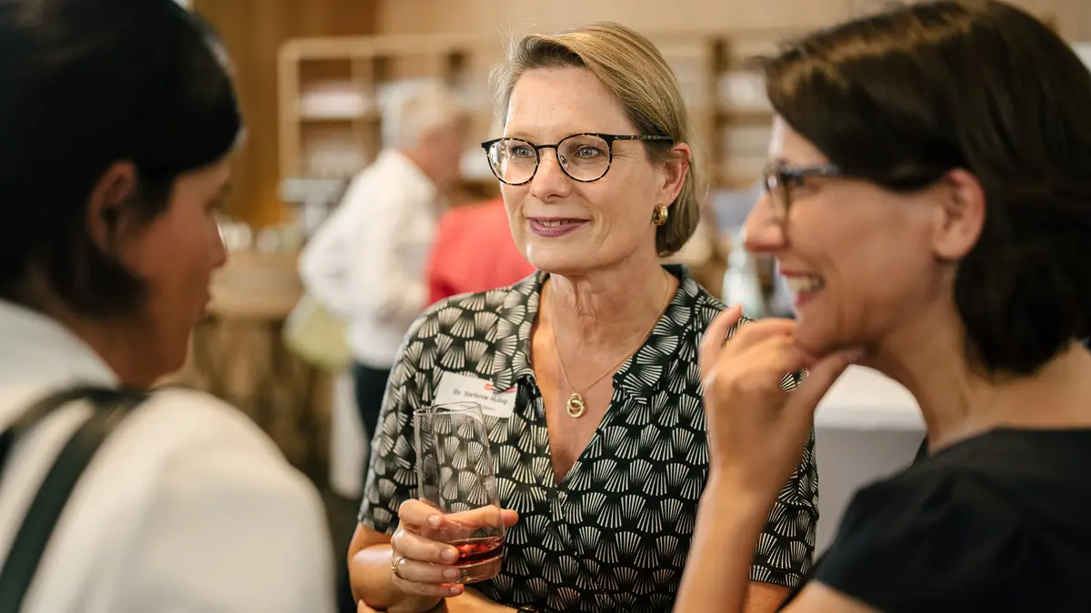 Drei Frauen vor einer Bar im Gespräch