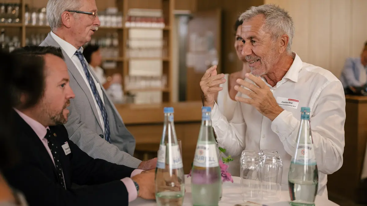 Drei Männer unterhalten sich angeregt.