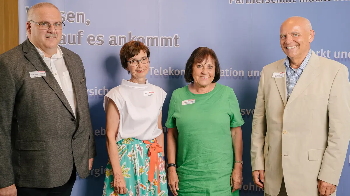 Mehrere Personen vor einer Fotowand