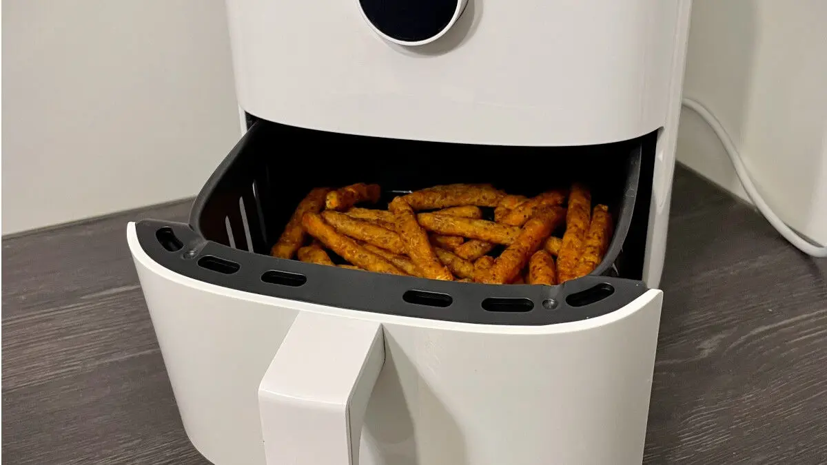 Eine geöffnete Heißluftfritteuse mit Blick auf frittiertes Gargut.