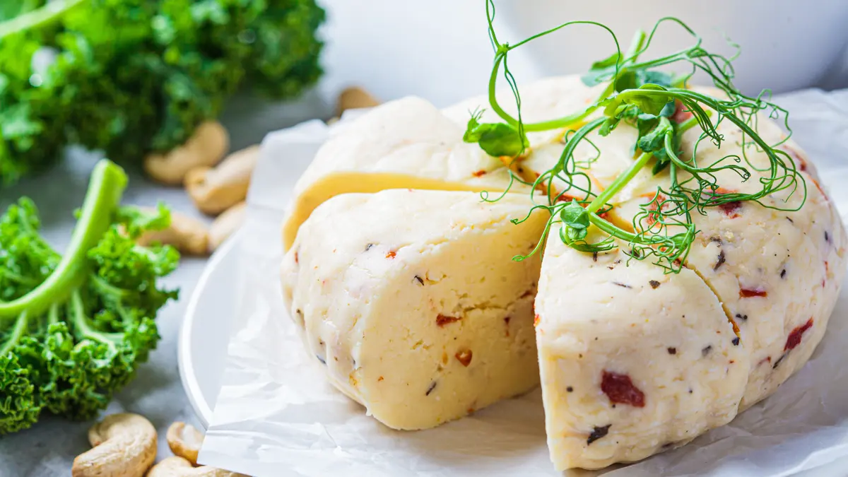 Ein veganer Käse aus Cashewkernen liegt auf einem Teller