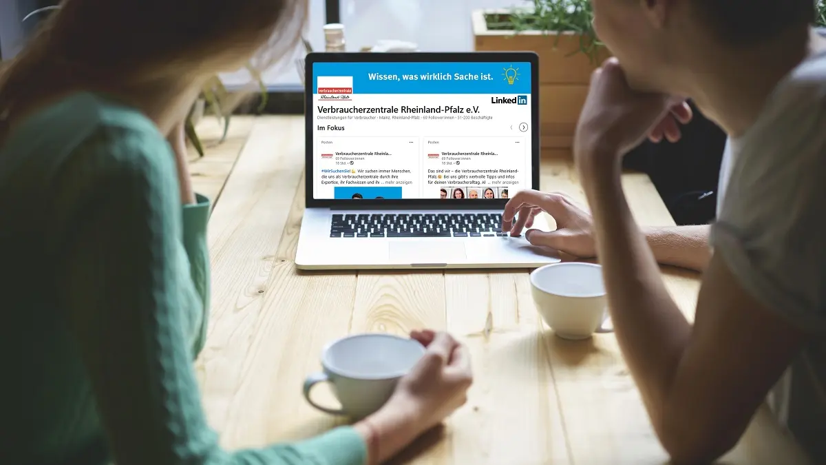 zwei Frauen sitzen vor einem PC auf dem LinkedIn geöffnet ist.