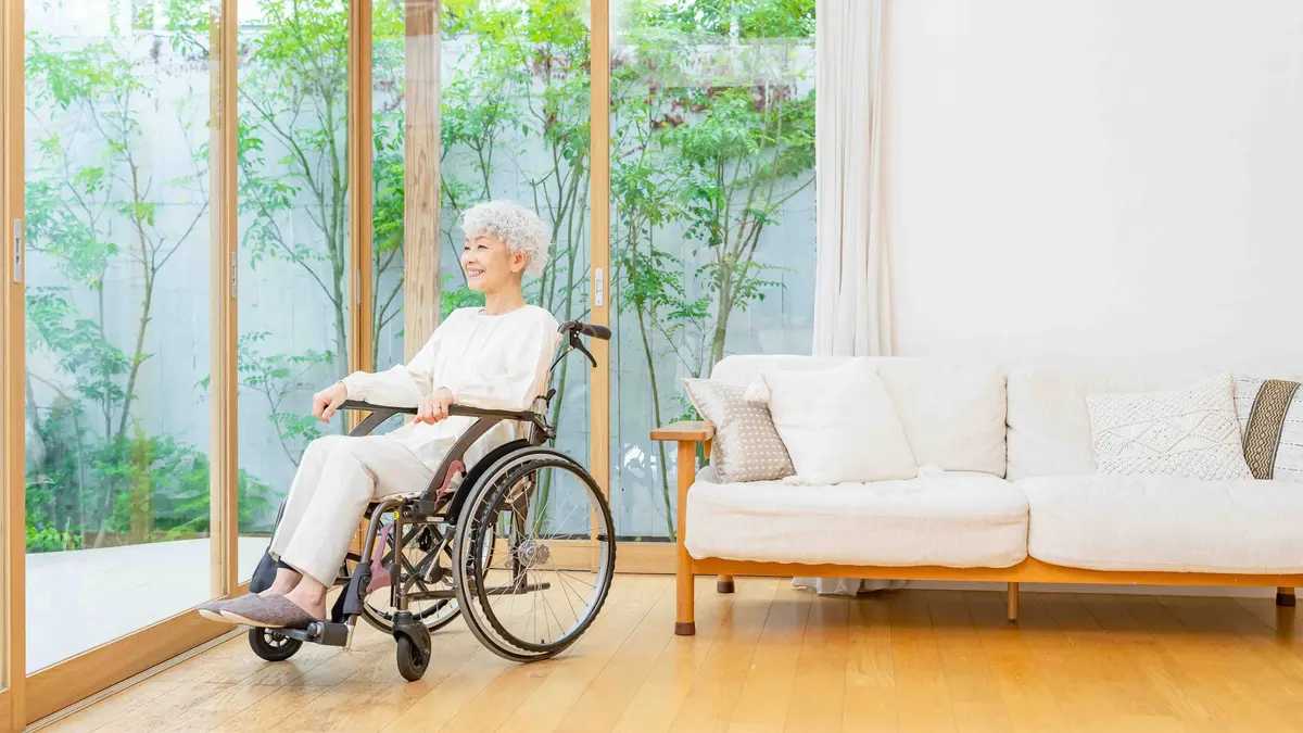 Frau im Rollstuhl schaut in den Garten
