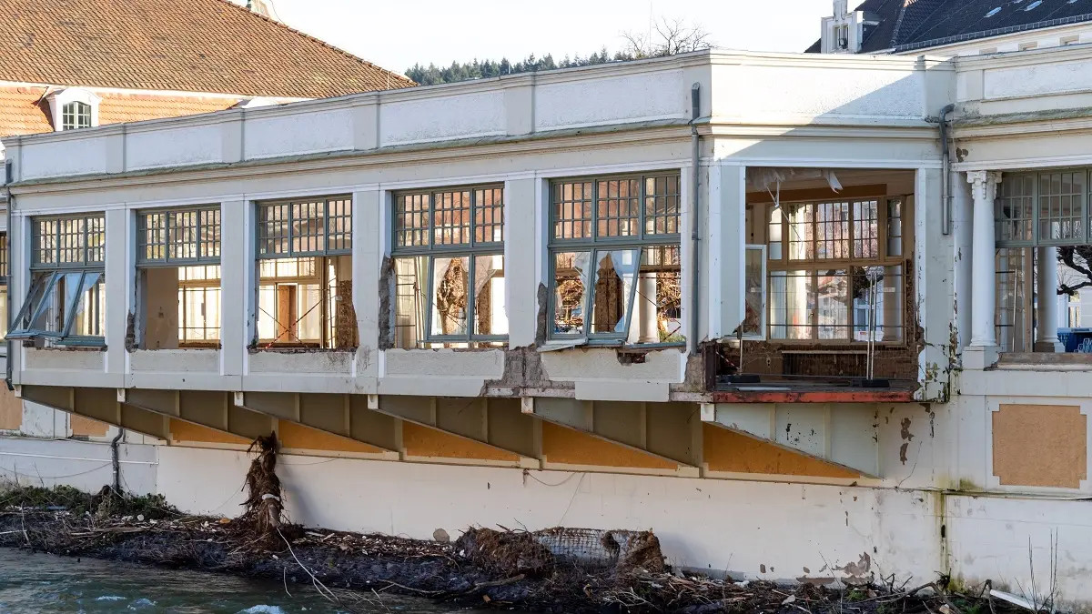 Ein halbzerstörtes Haus an einem Fluss.