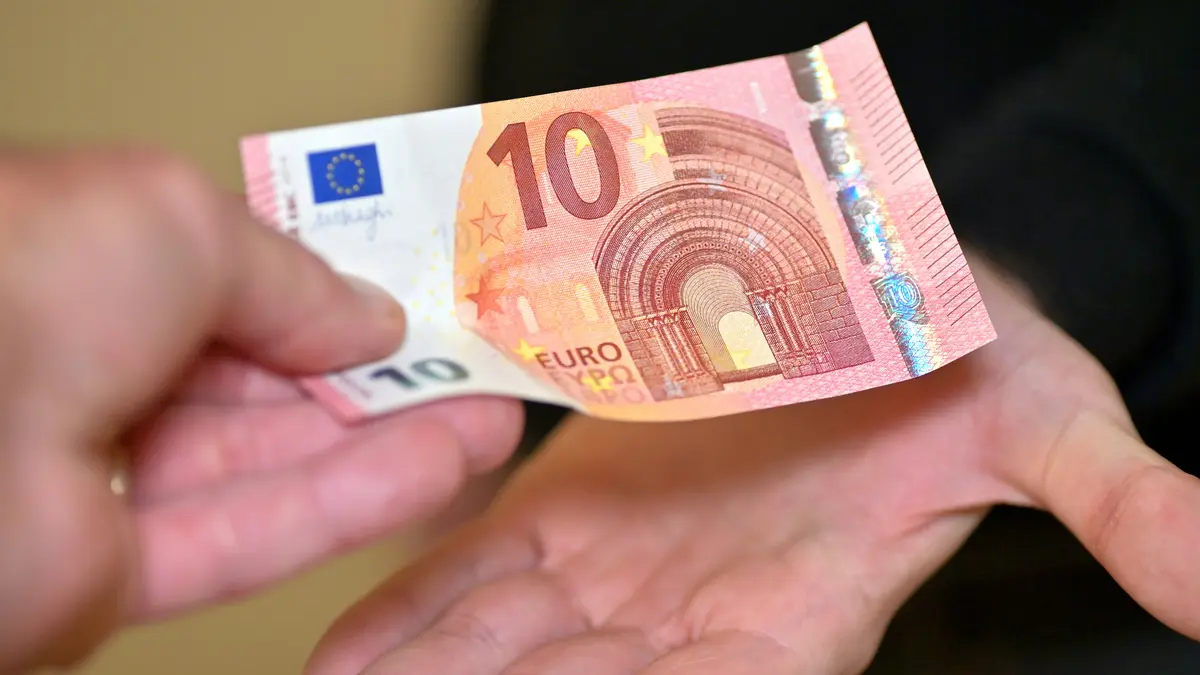 Geldschein geht von Hand zu Hand