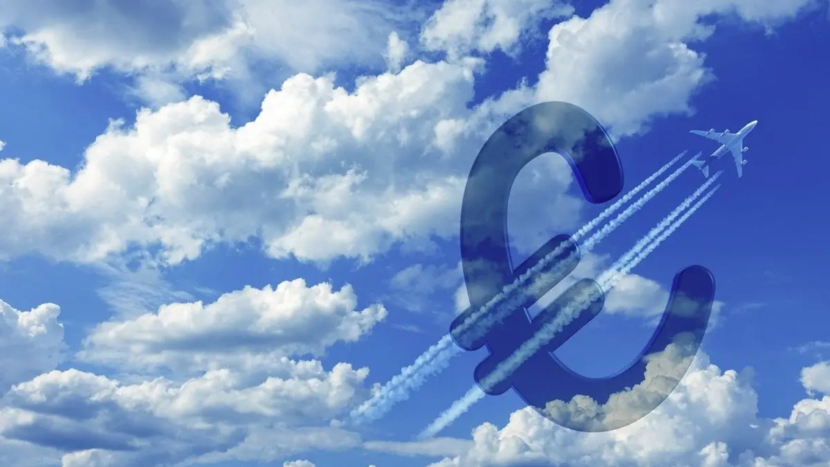 blauer Himmel mit einem Flugzeiúg, das durch ein Euro-zeichen fliegt