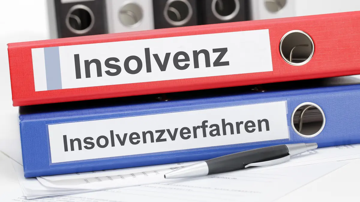 Zwei übereinander liegende Aktenordner, einer mit der Aufschrift Insolvenz, einer mit Insolvenzverfahren