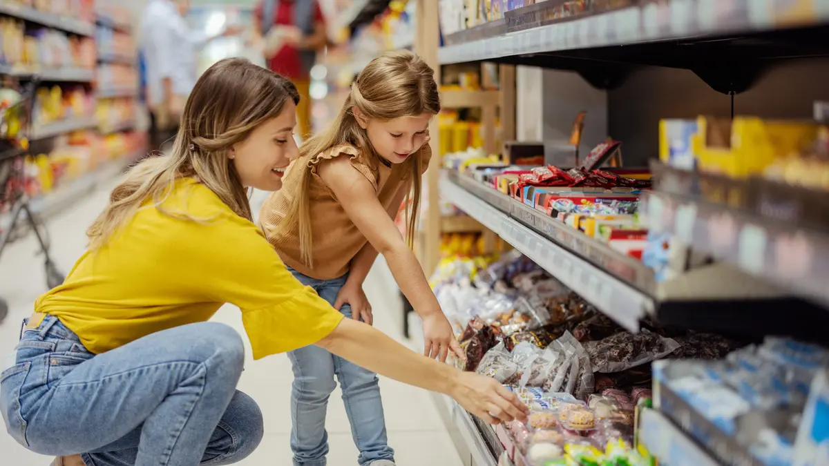 Frau mit Kind am Supermarktregal