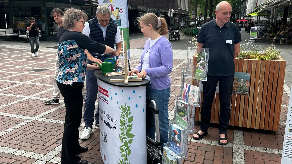 Infostand an der Ausstellung mit interessierten Personen und Beratungspersonal