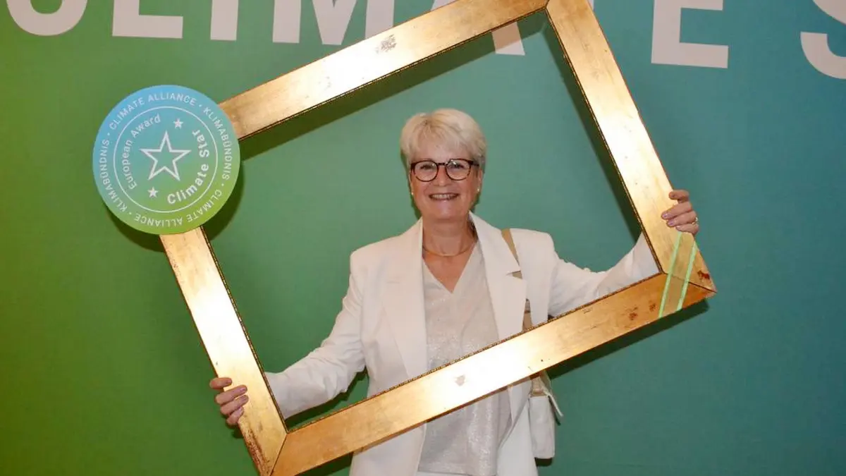 Energieberaterin Susanne Berger posiert mit dem goldenen Fotorahmen des Climate Star Awards 2025