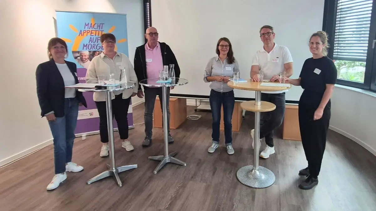 Teilnehmende und Referent:innen an Stehtischen