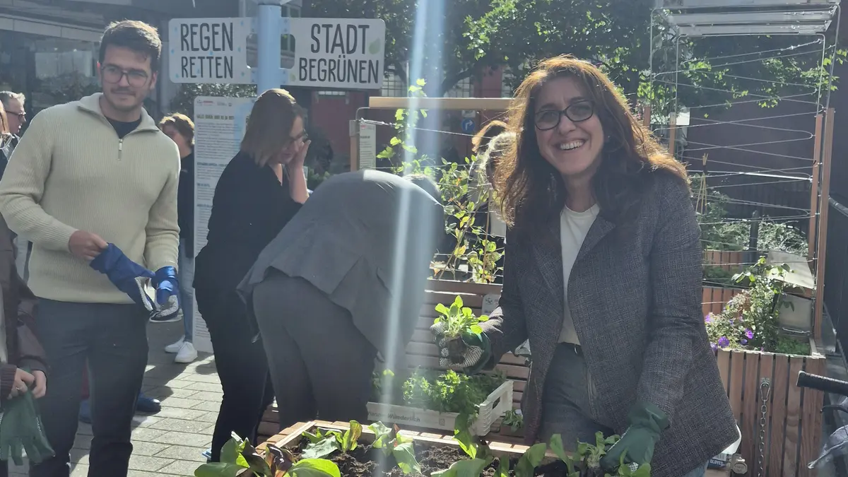 Fatma Özkan (Leiterin Gruppe Klimaanpassung VZ NRW) bepflanzt ein Hochbeet