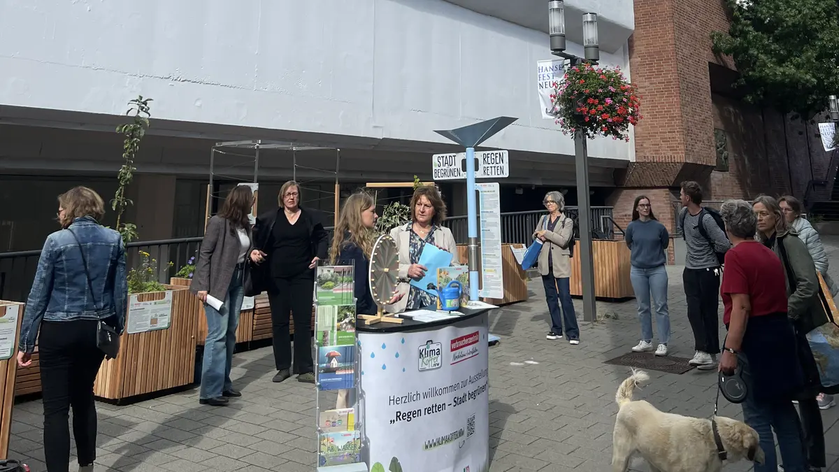 Veranstaltungstresen der Ausstellung mit Glücksrad und Menschen am Stand