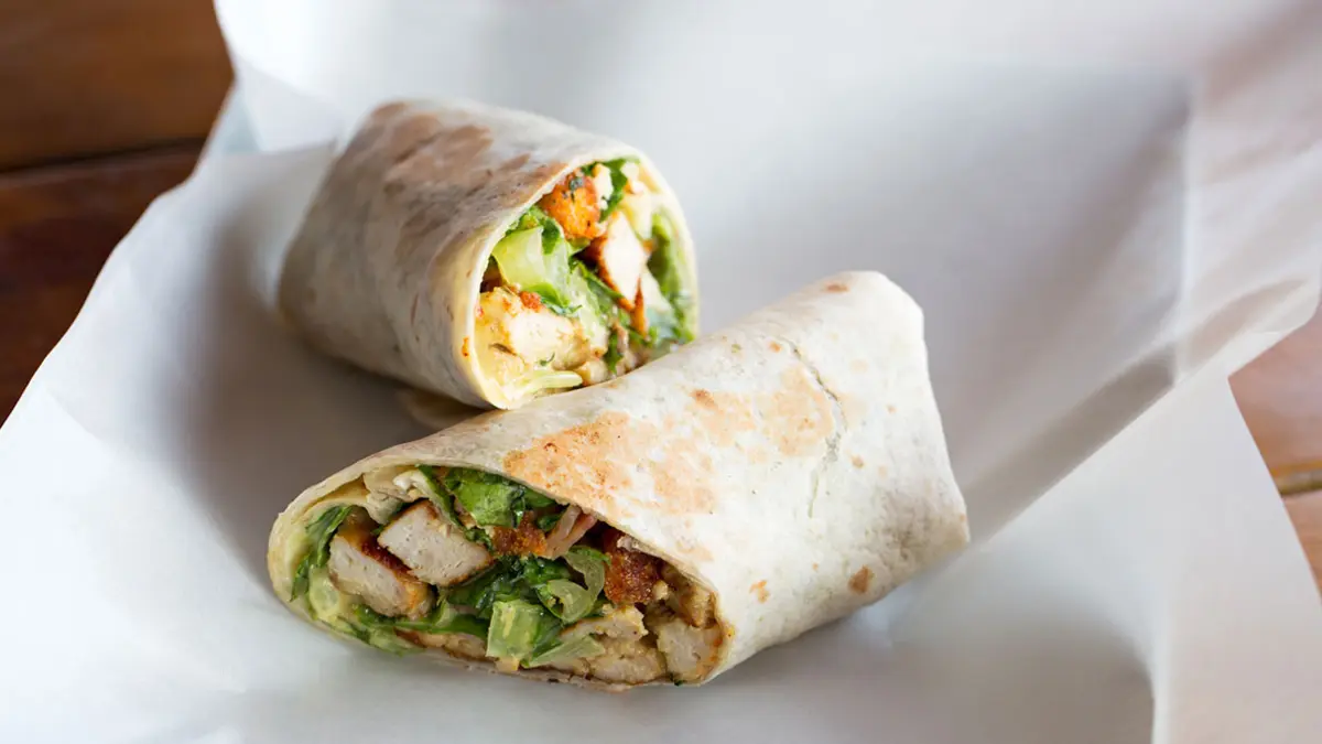 Zwei Hälften eines Wraps liegen auf einem weißen Teller