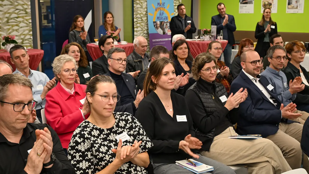 Die Teilnehmenden klatschend während eines Vortrags