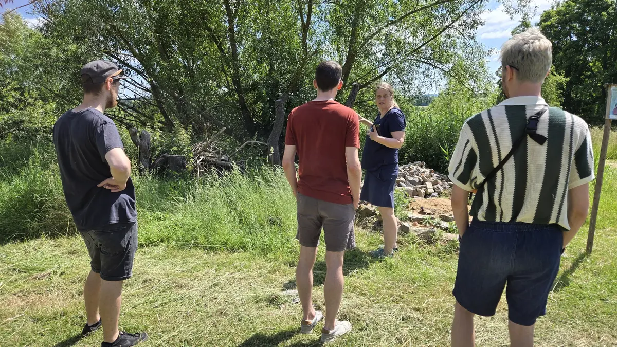 Frau erklärt Interessierten Naturgarten