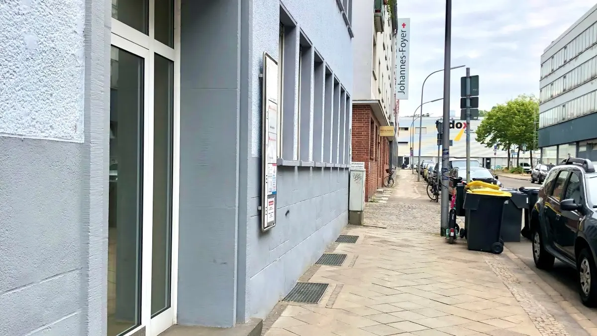 Straße mit parkenden Autos, Eingang eines Hauses mit der Hausnummer 63