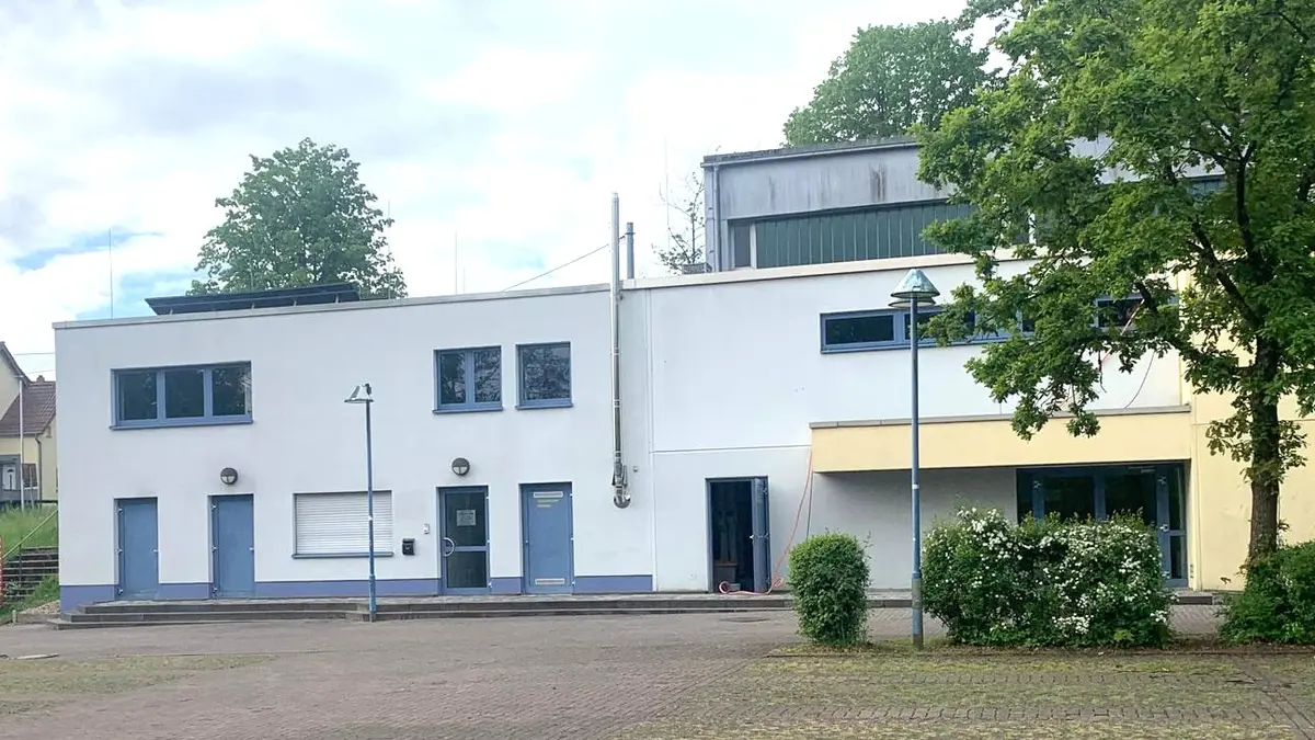 zweistöckiges Gebäude mit weißem Anstrich und blauen Türen