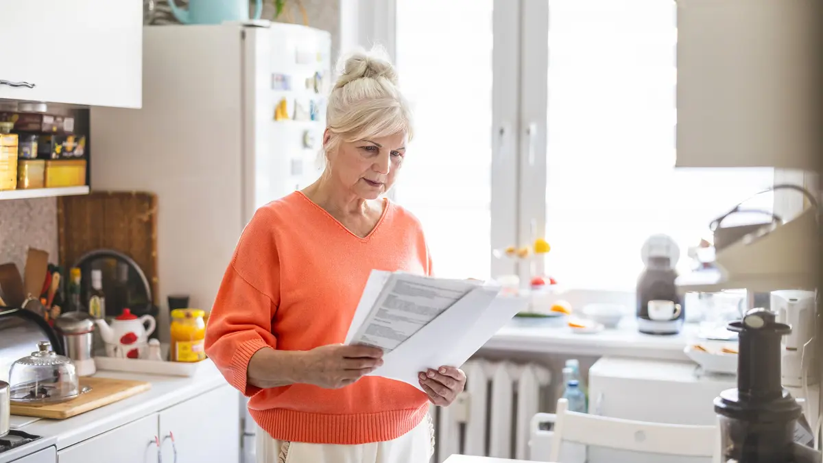 Frau öffnet Rechnung in der Küche