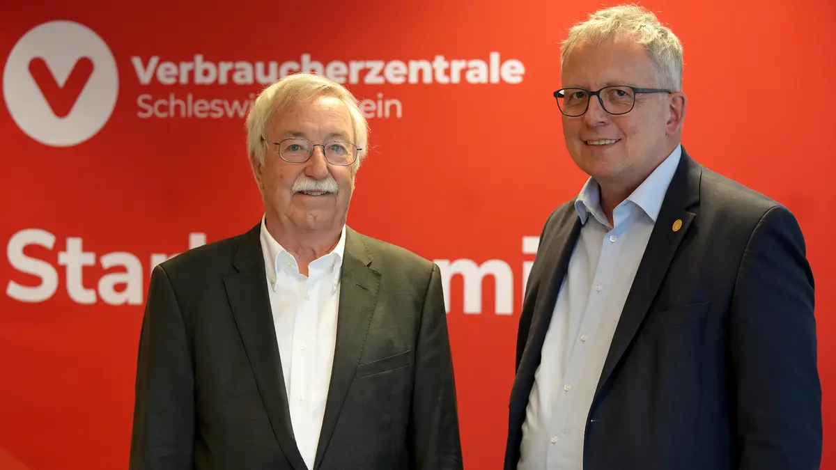 Zwei Männer stehen vor einer Messewand