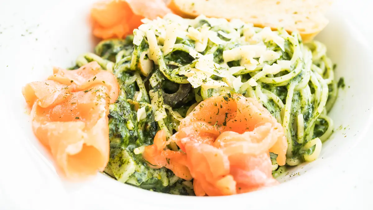Eine Schüssel mit Nudeln, Pesto und Lachs