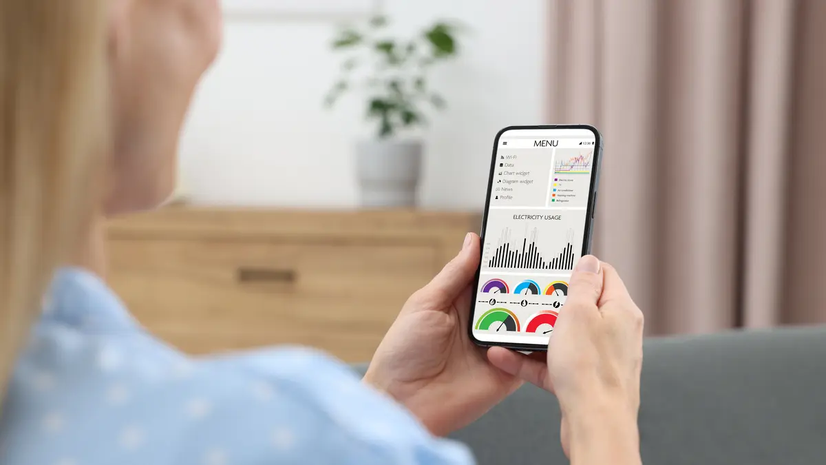 Frau schaut auf Handy dynamische Stromtarife an