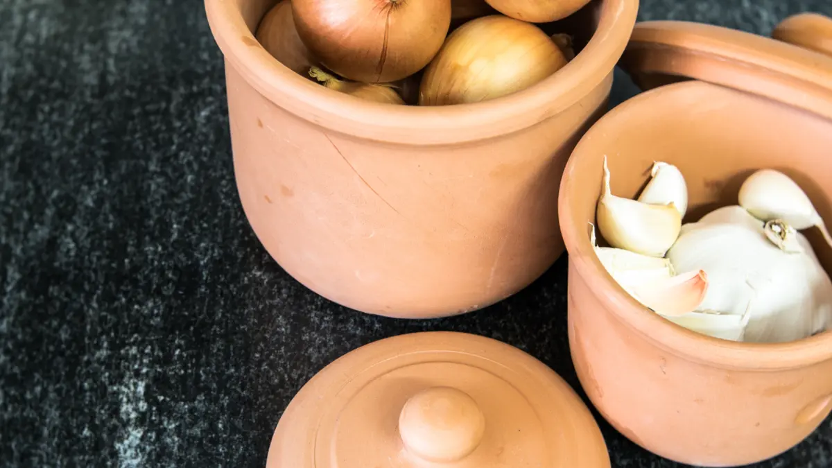Zwei Römertöpfe mit Zwiebeln und Knoblauch drin