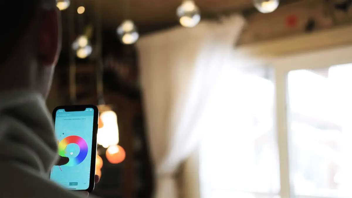 Mann steuert sein Licht mit dem Smartphone