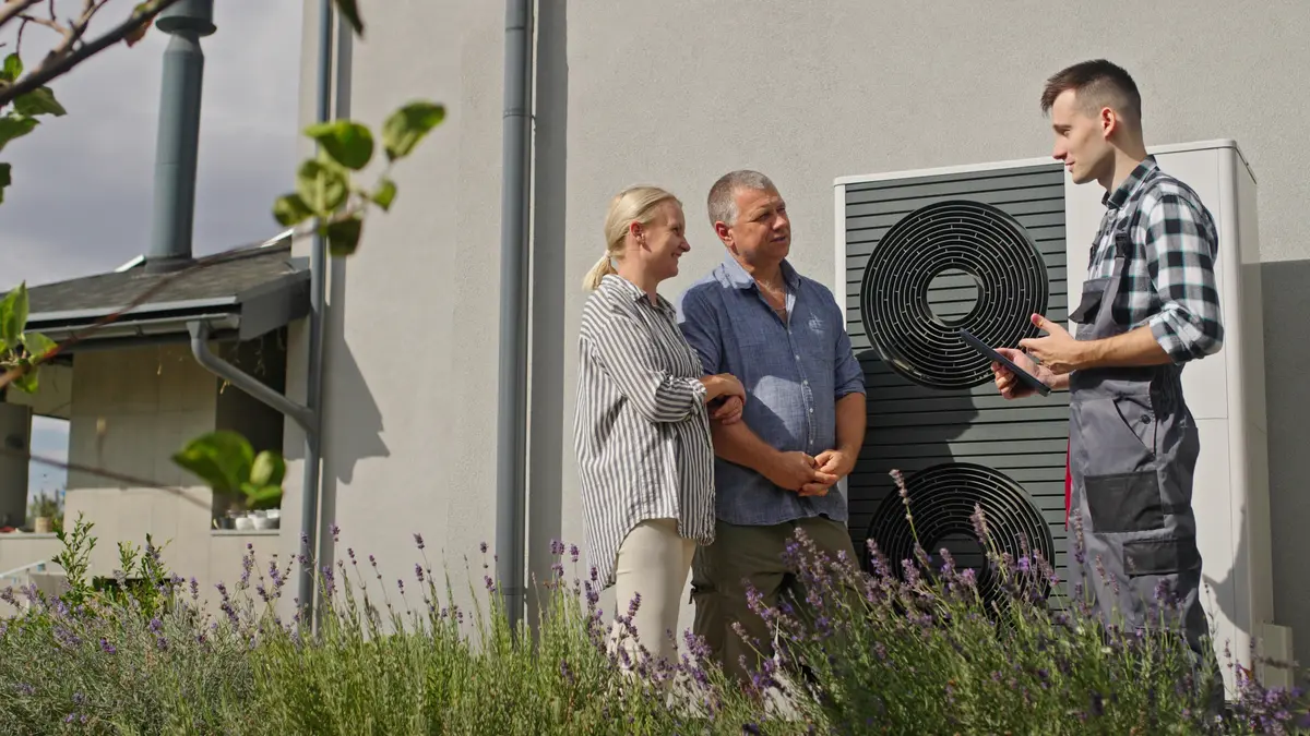 Paar mit Techniker vor Wärmepumpe