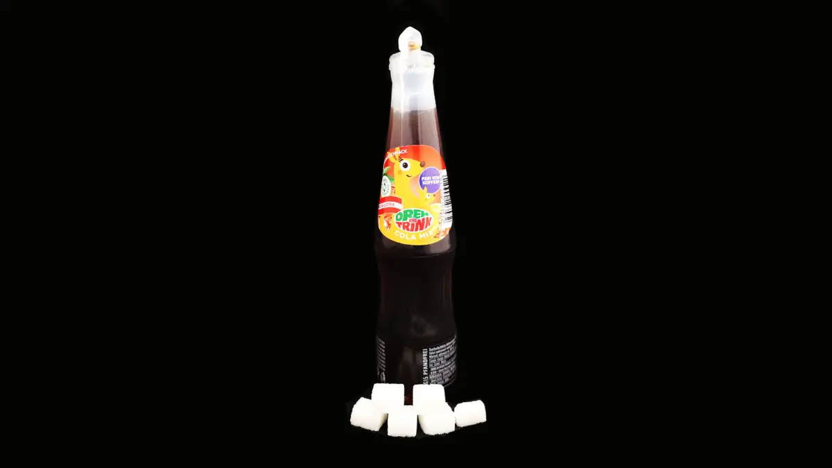 Flasche dreh und trink cola mix auf schwarzem Grund mit 5,5 Zuckerwürfeln davor