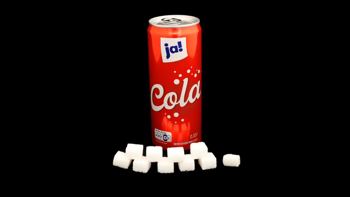 Dose Ja! Cola auf schwarzem Grund mit 9,5 Zuckerwürfeln davor