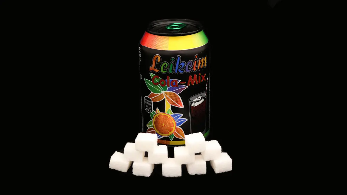 Dose leikeim Colamix auf schwarzem Grund mit 11 Zuckerwürfeln davor