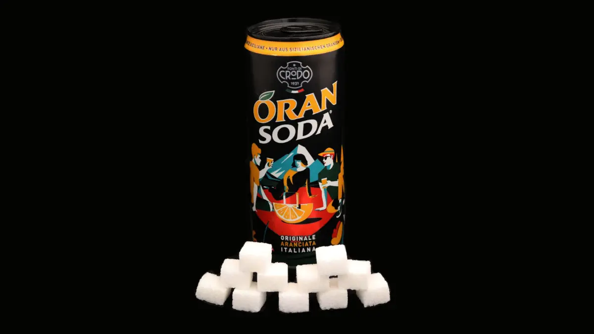 Dose Oran Soda auf schwarzem Grund mit 11 Zuckerwürfeln davor