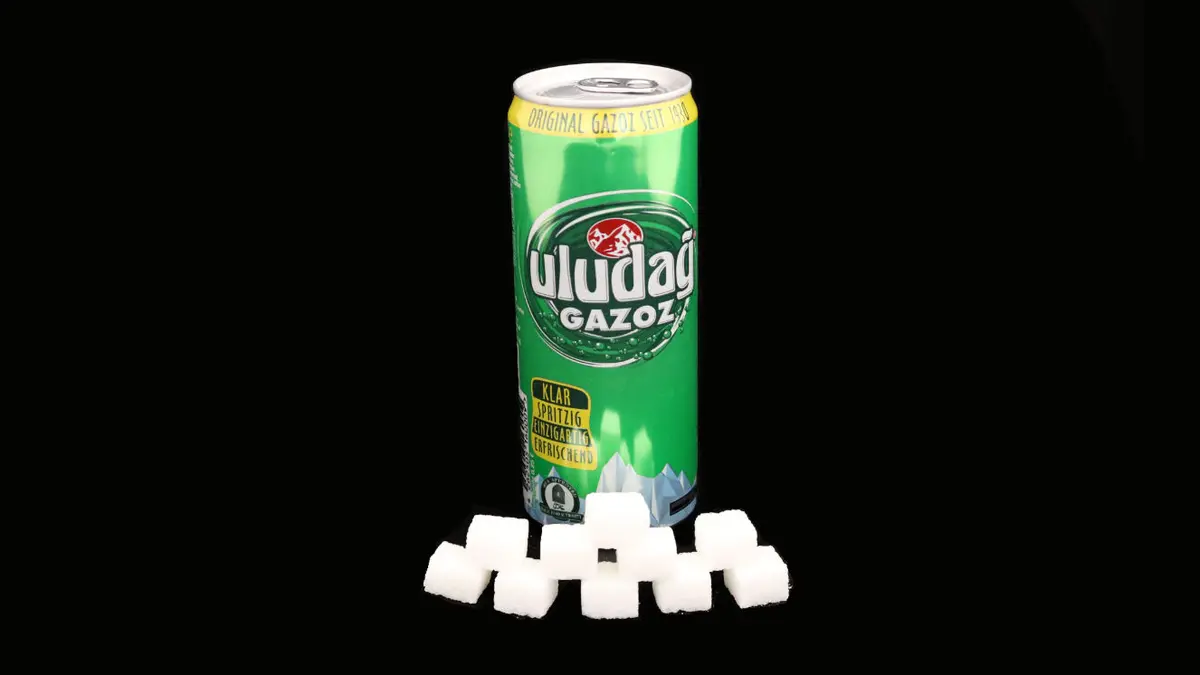 Dose uludag Gazoz auf schwarzem Grund mit 10 Zuckerwürfeln davor